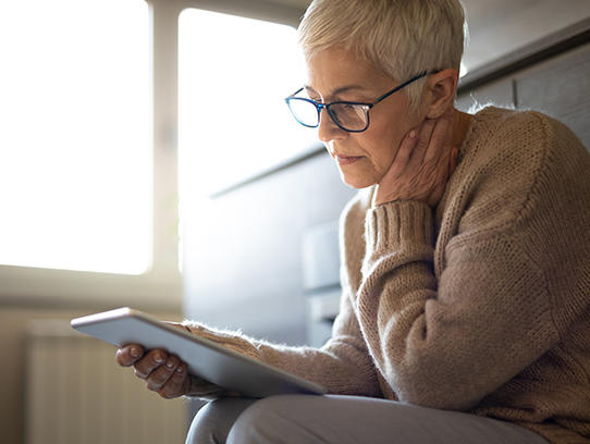 Mujer mayor leyendo en una tableta