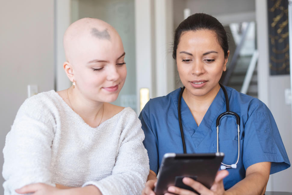 A woman with cancer is meeting with her female doctor.