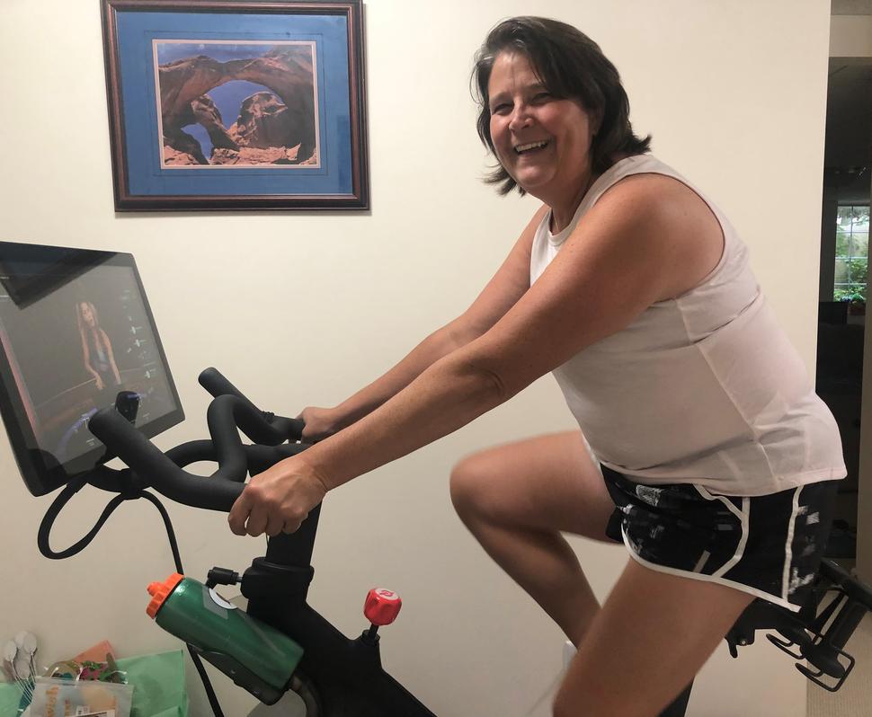 Dawn Schnell, una sobreviviente de cáncer, montada en una bicicleta estática