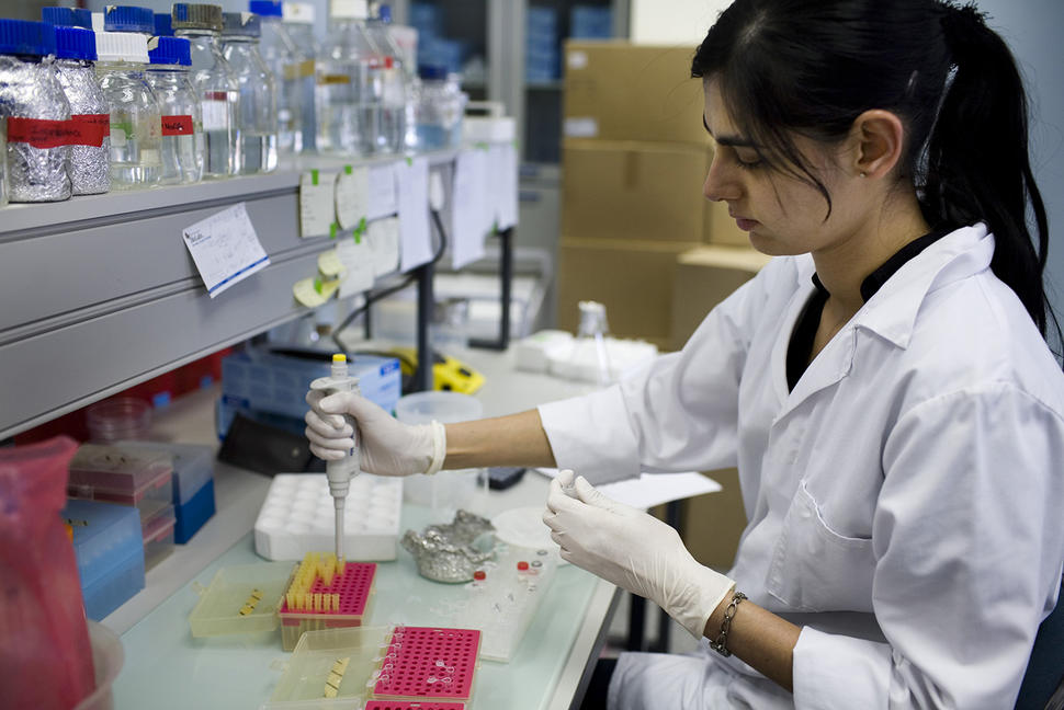 Female researcher in lab uses a pipette