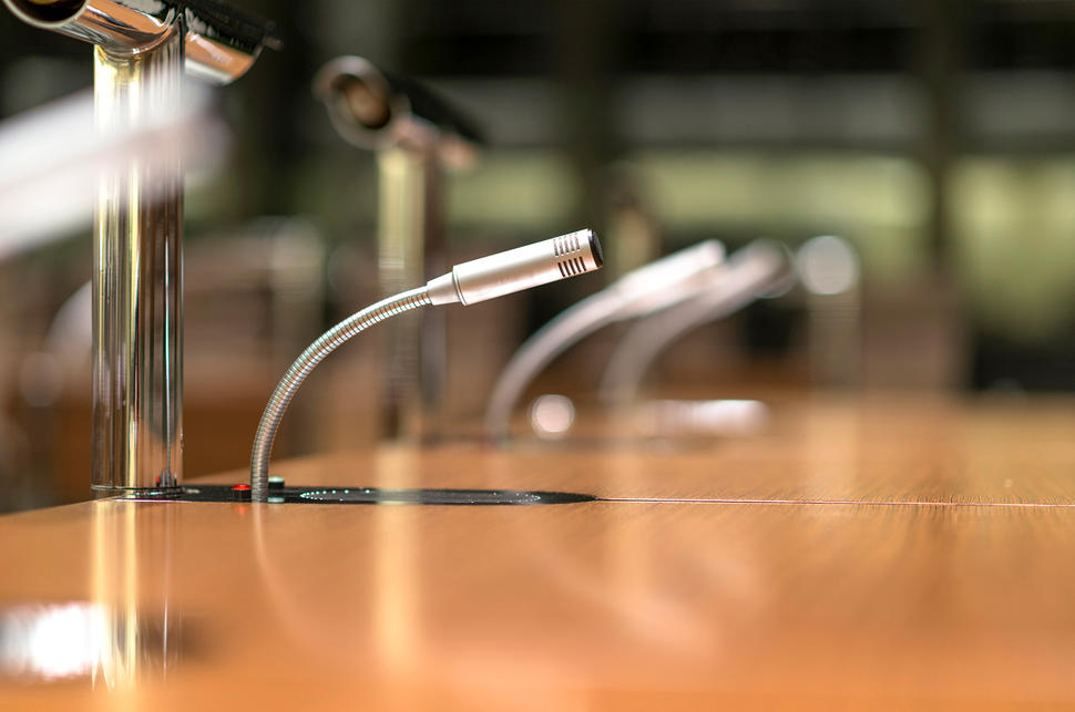 Photo of slender, silver microphone on desk