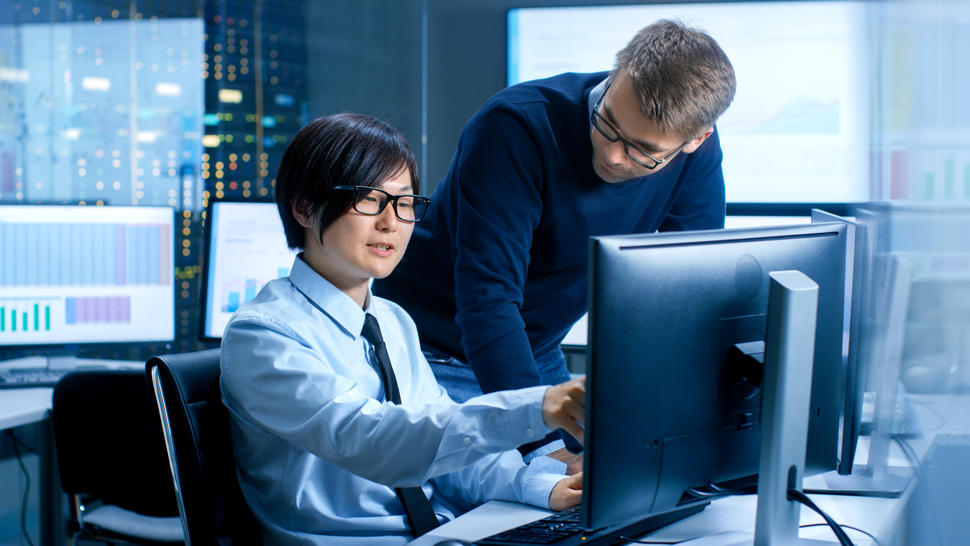 Young asian man with supervisor looking at monitor