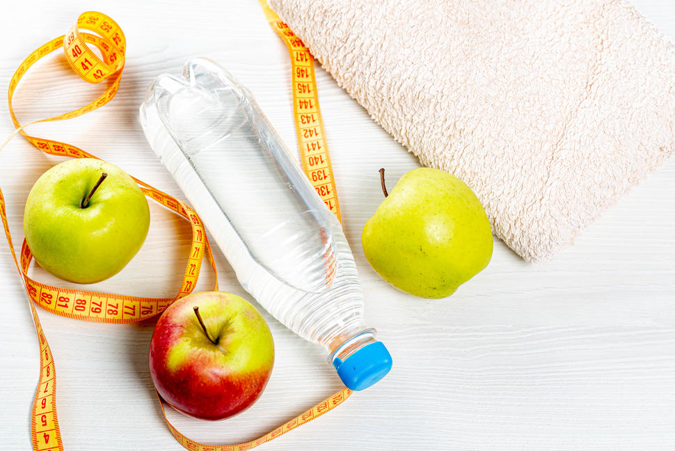 Photo of three apples, a bottle of water, a measuring tape, and a towel