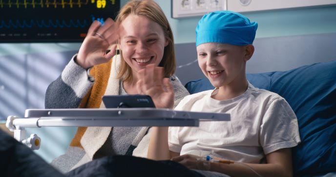 A child with cancer and his mother talking with family via a tablet computer.