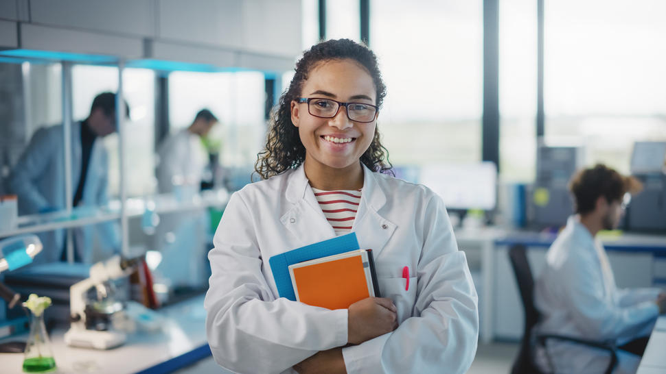 Science Laboratory:Young Black Scientist with White Coat and Glasses, Holds Books