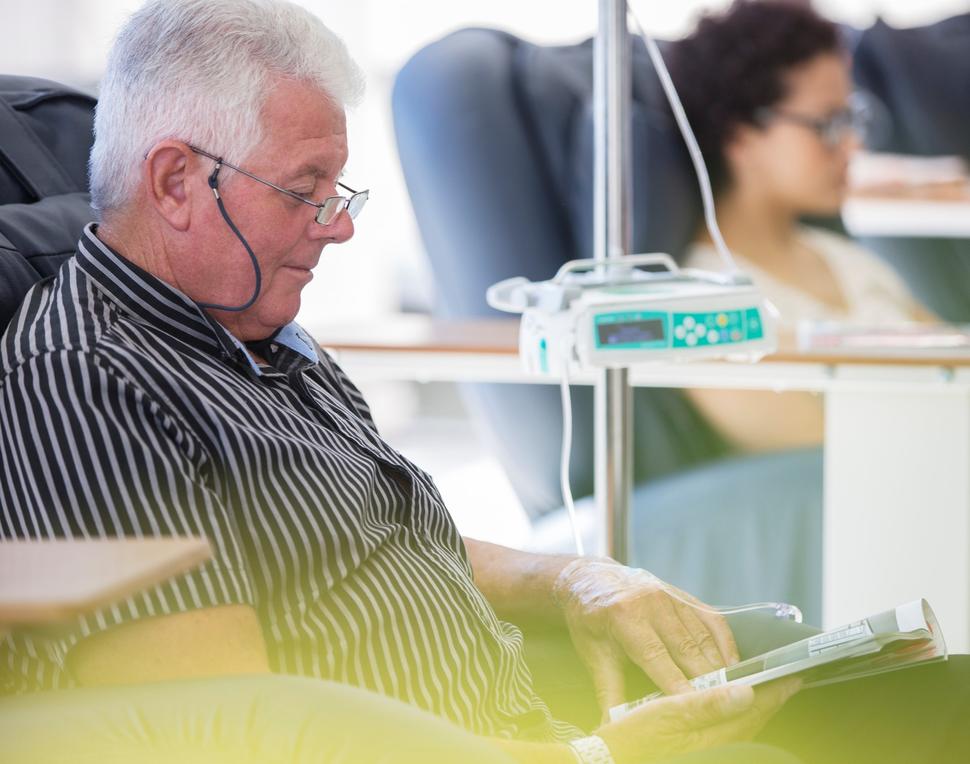 An older man in a recliner receiving outpatient IV cancer medication