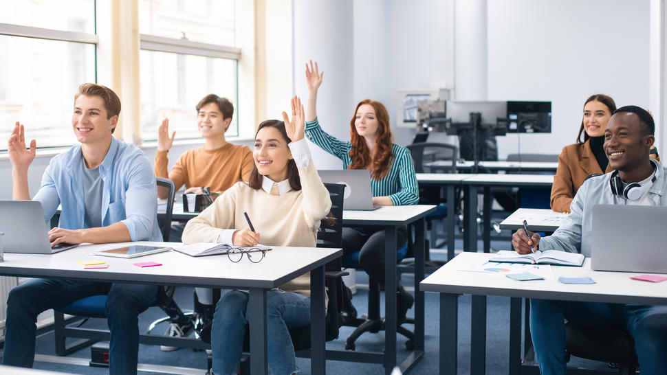 ultural people raising hands to agree or to ask questions at modern seminar in office, diverse mixed