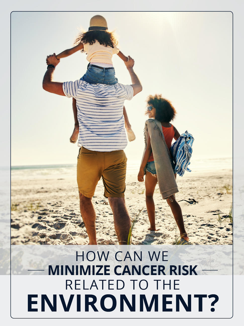 A family of three walking at the beach. One parent wears a backpack and carries a beach towel. The other parent has a child on their shoulders.