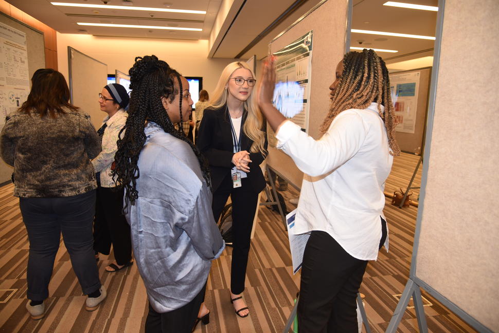 Nadine Dogbe, BA, right, speaking with Mahider Enyew, BS, and Erika Kaschak, BA.