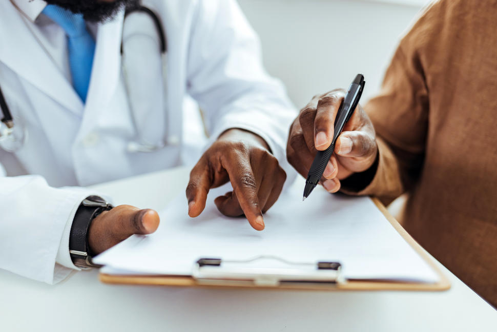 Understanding informed consent forms: A doctor and patient reviewing a medical form.