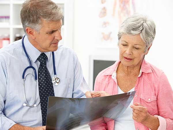 an older woman and her doctor look at an x-ray together