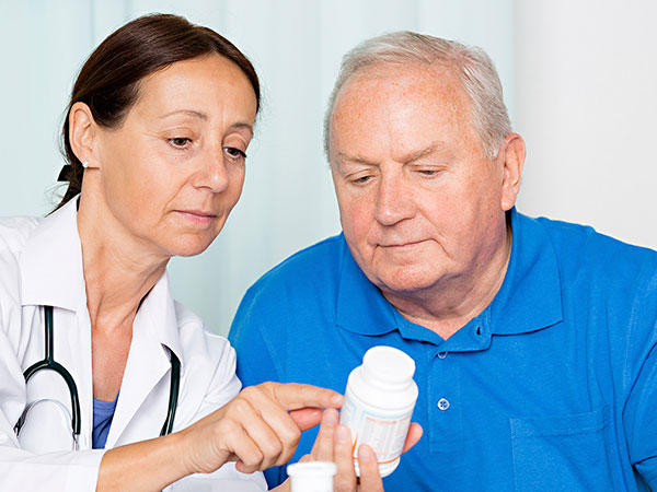 Doctor explaining when and how often to take medicine for pain, to a man with cancer. 