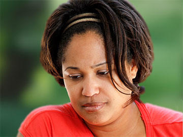 headshot of woman with downcast eyes and sad expression