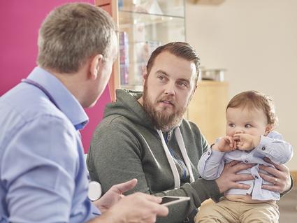 A father speaking with his toddler's pediatrician.