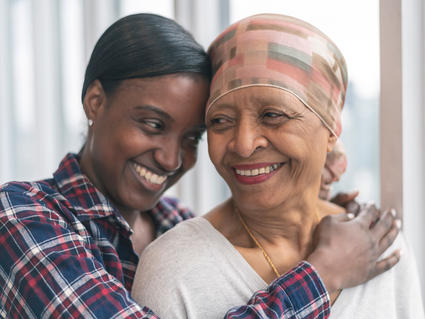 African-American daughter hugging mother and smiling