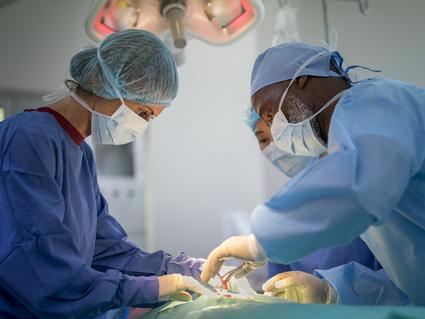 Photo of doctors performing surgery in a hospital operating room.