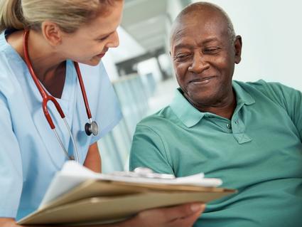 A nurse showing an African American man his test results.