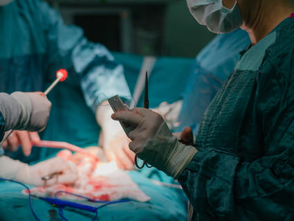 Un equipo quirúrgico al rededor de un paciente en una sala de operaciones