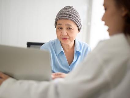 An older female woman wearing a winter cap with female doctor.