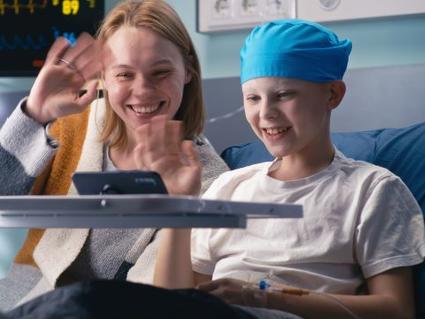 A child with cancer and his mother talking with family via a tablet computer.