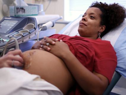 A young pregnant woman undergoing an ultrasound in the doctor's office