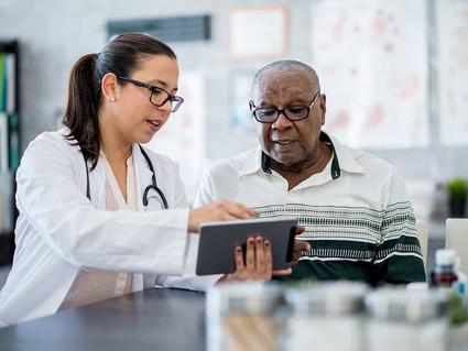 Doctor and patient looking at a tablet computer. 