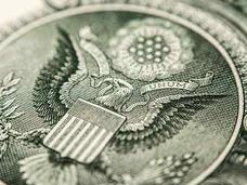 A close-up image of the seal of the United States on a US dollar bill. 