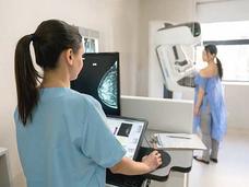 Woman undergoes mammography with health care provider.