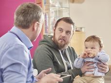 A father speaking with his toddler's pediatrician.