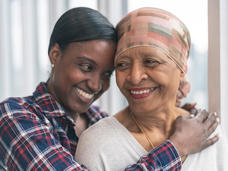 African-American daughter hugging mother and smiling