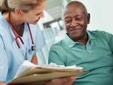 A nurse showing an African American man his test results.