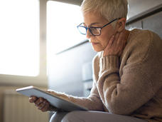 Middle aged woman reading a tablet