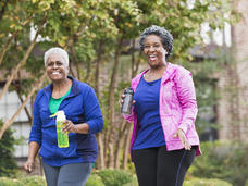 two middle aged women walking outside, laughing