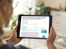 Woman holding a tablet showing a clinical trial summary