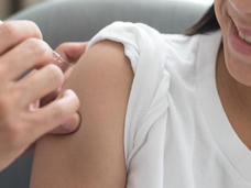Imagen de una niña que recibe la inyección de una vacuna en el antebrazo.