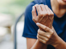 Una mujer joven con dolor en las articulaciones de la mano