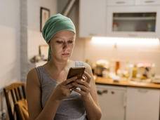 teen with head scarf looking at her phone