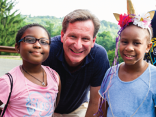 El director del Instituto Nacional del Cáncer (NCI), Ned Sharpless, con dos niñas participantes del Camp Fantastic.