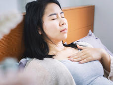 woman lying on a bed with her eyes closed