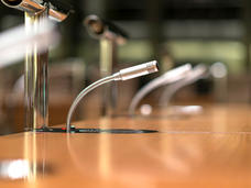 Photo of slender, silver microphone on desk