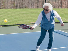 Una mujer adulta jugando "pickleball"
