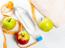 Photo of three apples, a bottle of water, a measuring tape, and a towel