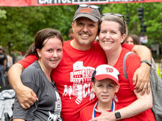 Jason Levine standing with his wife, daughter, and son at the finish line of a race.