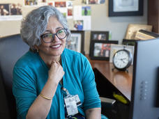 A woman, Dr. Smita Bhatia, sits in her office looking at her computer.