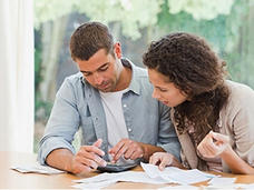 Two people reviewing papers at a desk. 