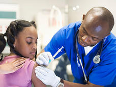 Doctor giving a girl a shot in the upper arm