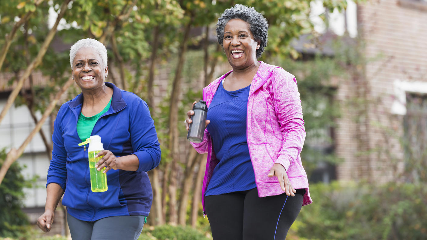 Two older Black women walking on a fall day.