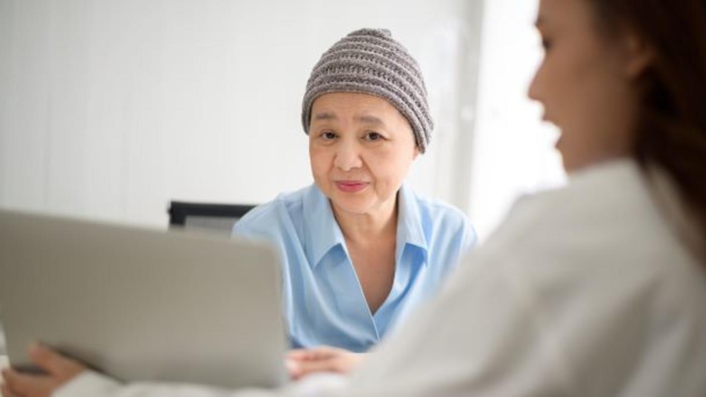 An older female woman wearing a winter cap with female doctor.