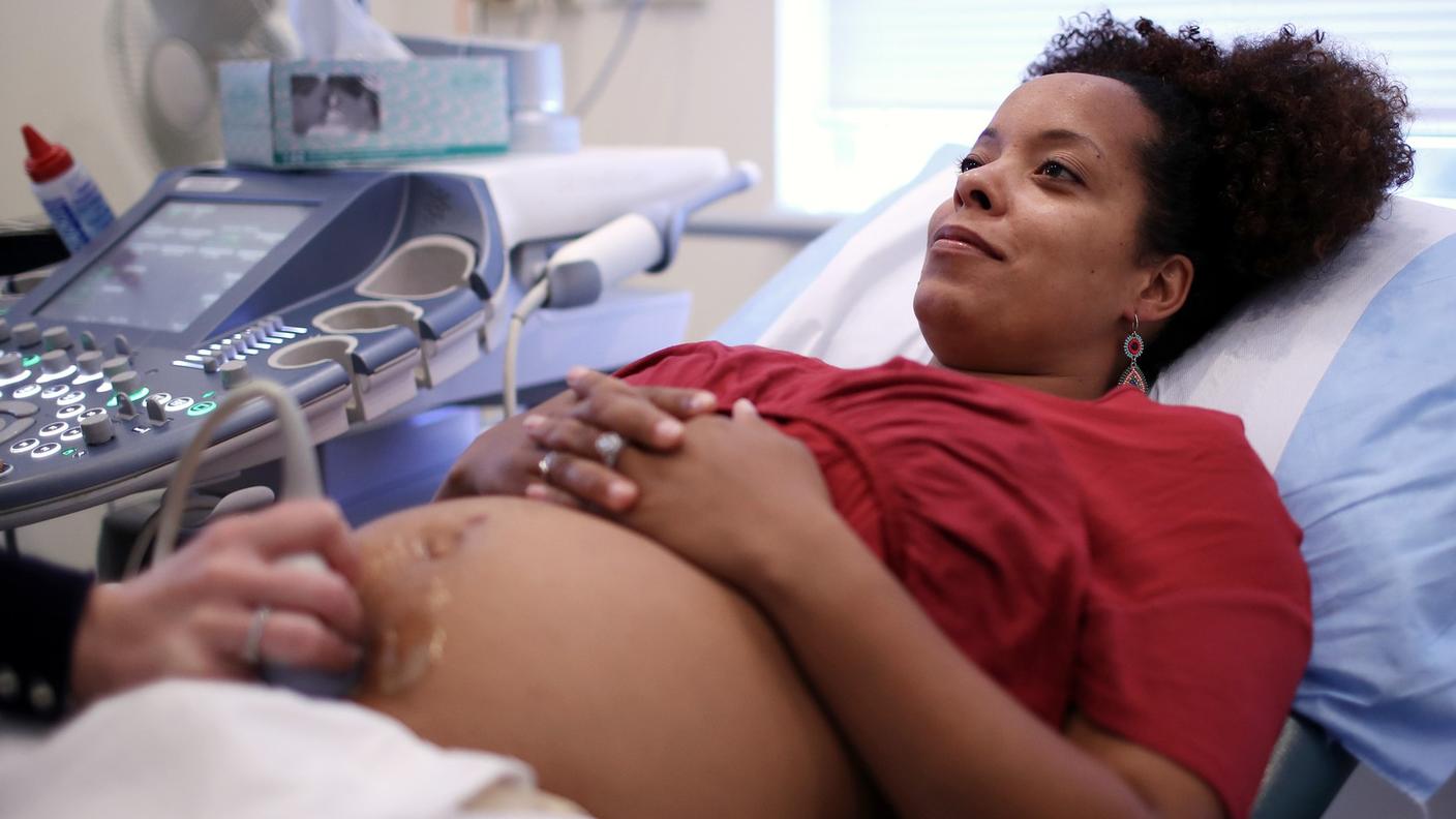 A young pregnant woman undergoing an ultrasound in the doctor's office