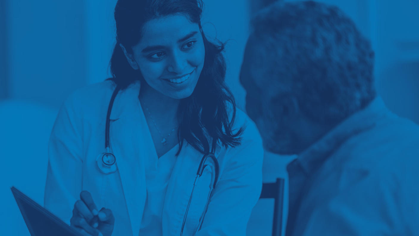 Health professional with clipboard speaks with patient.